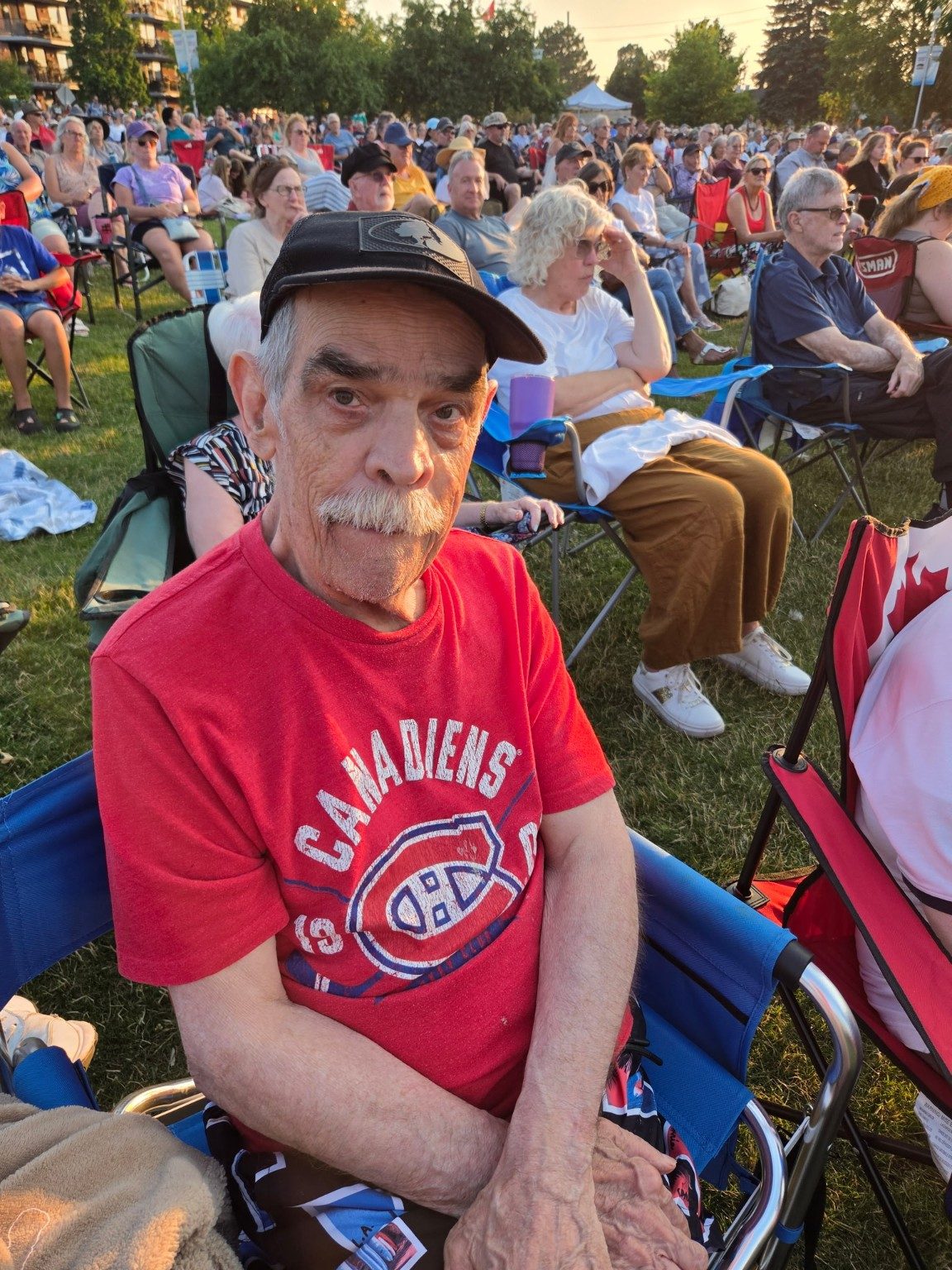 A man in a Canadiens shirt enjoying an outdoor concert alongside the crowd