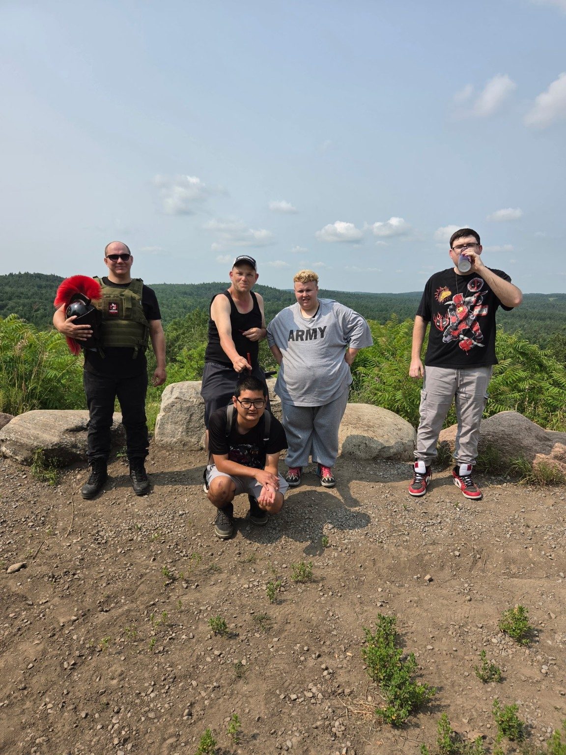 Five people from the Access community standing together at a hilltop lookout on a sunny day